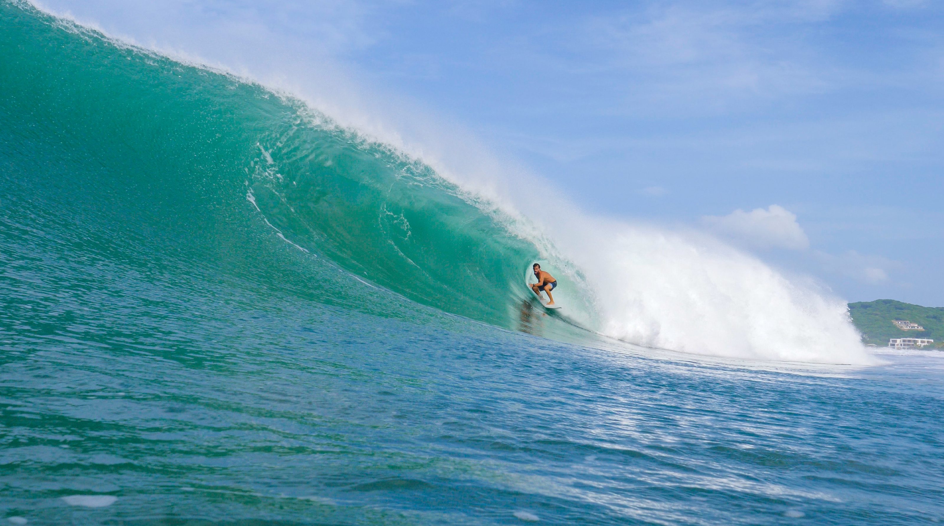 Surfista en una ola hueca y turquesa en Nicaragua