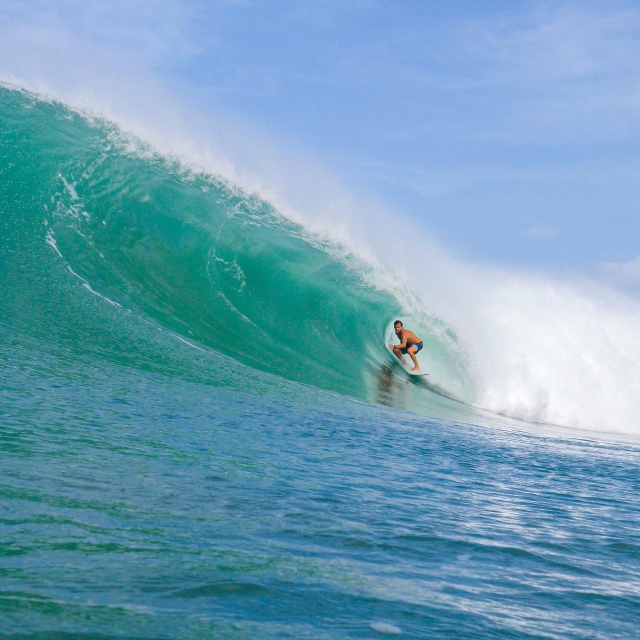Surfista en una ola hueca y turquesa en Nicaragua