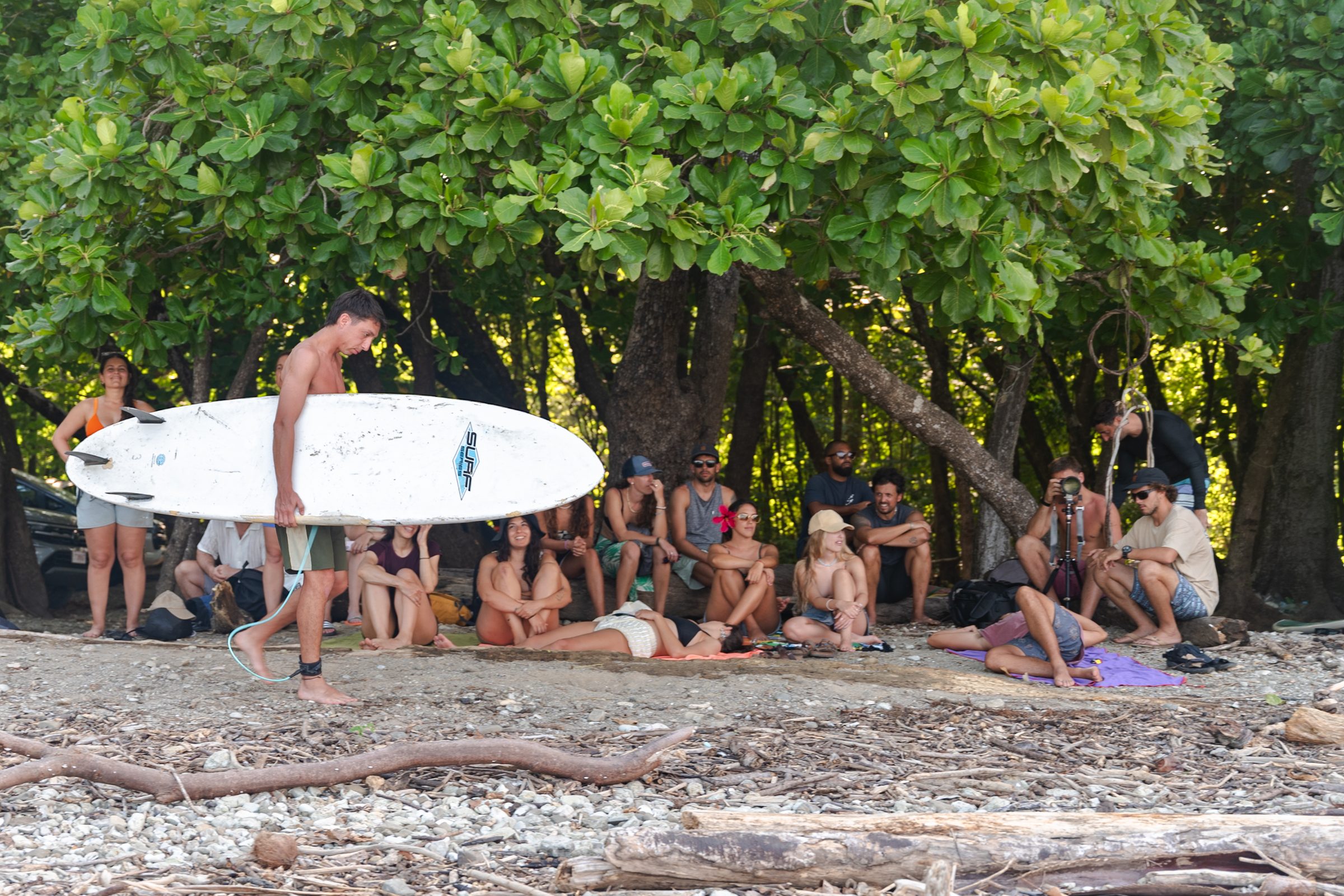 Grupo de Mango descansando en la playa de Costa Rica, con un surfista y su tabla