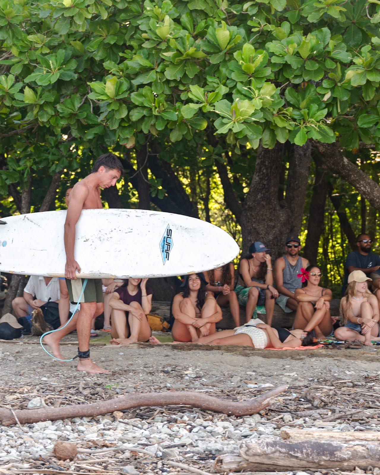 Grupo de Mango descansando en la playa de Costa Rica, con un surfista y su tabla
