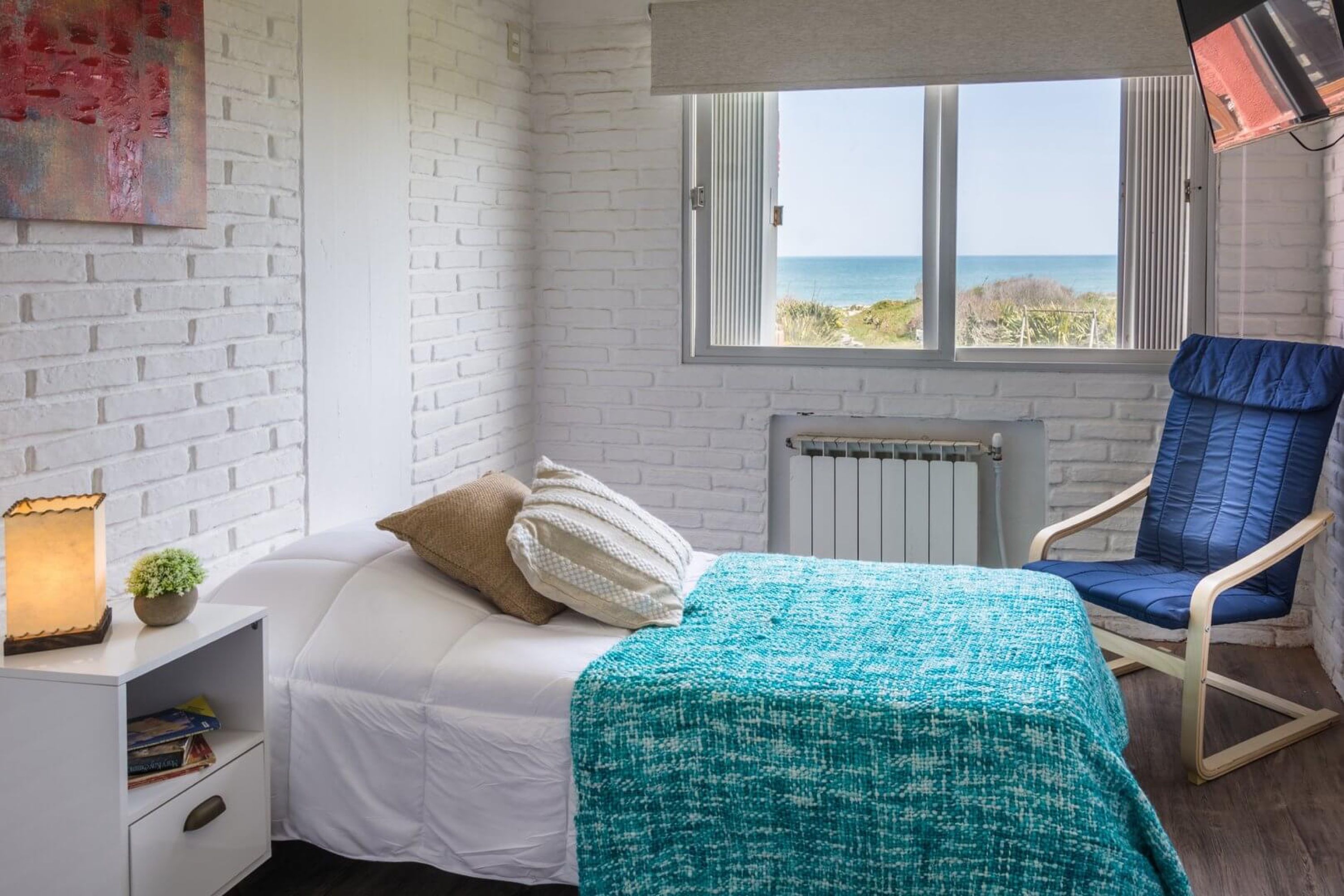 Habitación con cama y ventana al mar en Portobello Suites
