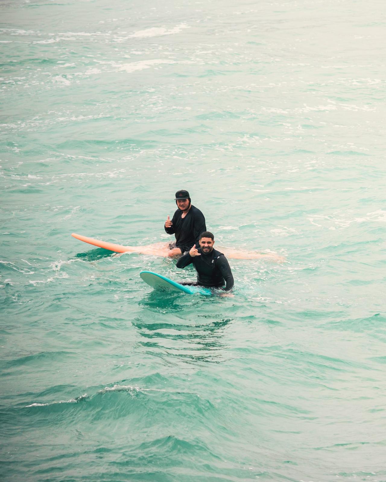 Clase de surf con coach dentro del agua