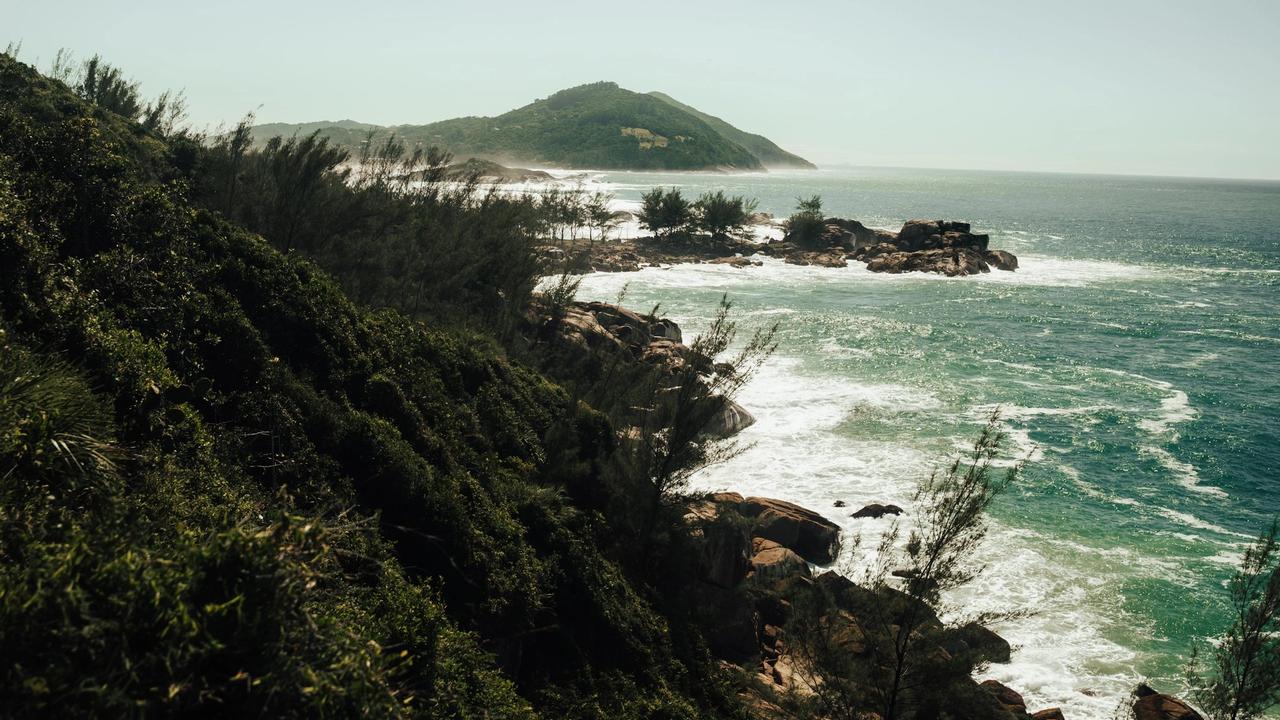 Costa del sur de Brasil con vegetación sobre las rocas y el mar verde, vista desde lo alto