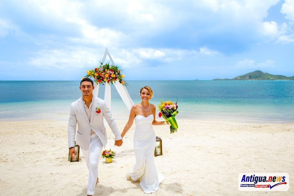  A couple celebrates their love against the stunning backdrop of Antigua and Barbuda's turquoise waters and pristine white sand beaches. 