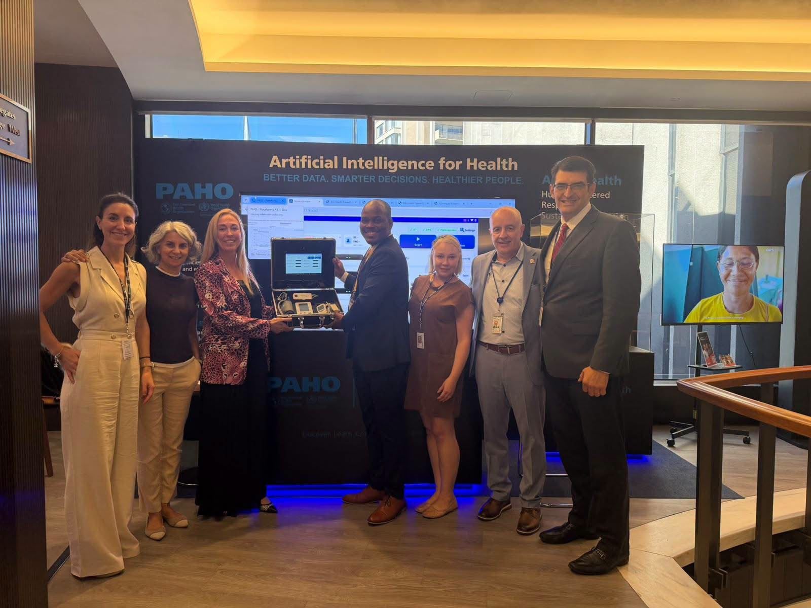 Health officials and representatives pose together at a Pan American Health Organization (PAHO) Artificial Intelligence for Health display, where digital technology and its potential applications in healthcare are being showcased.