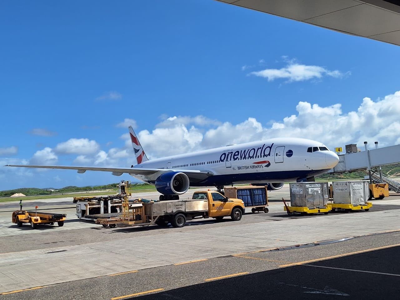 A British Airways aircraft sits on the apron at V.C. Bird International Airport as ground crews service the plane.