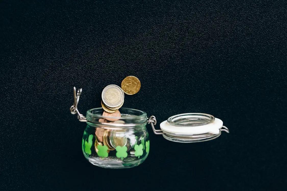 A glass jar filled with coins representing retirement savings and tax-deferred contributions for small business owners