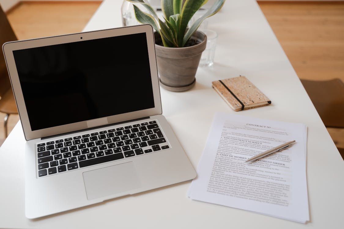 A clean home office setup with a laptop on a wooden desk representing a dedicated workspace used exclusively for business