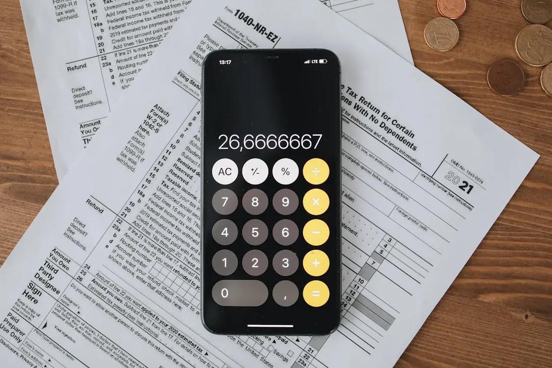Tax forms spread out next to a calculator representing business equipment deductions and depreciation planning