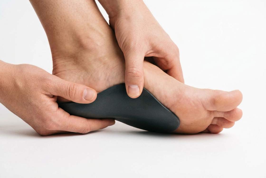 Custom orthotic held against the arch of a foot