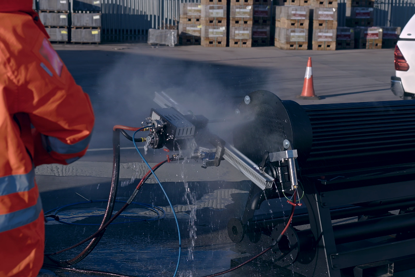 Operative using a jet wash for cleaning pipework
