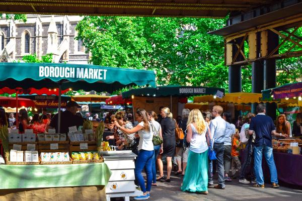 Pedestrians crossing through a London market street