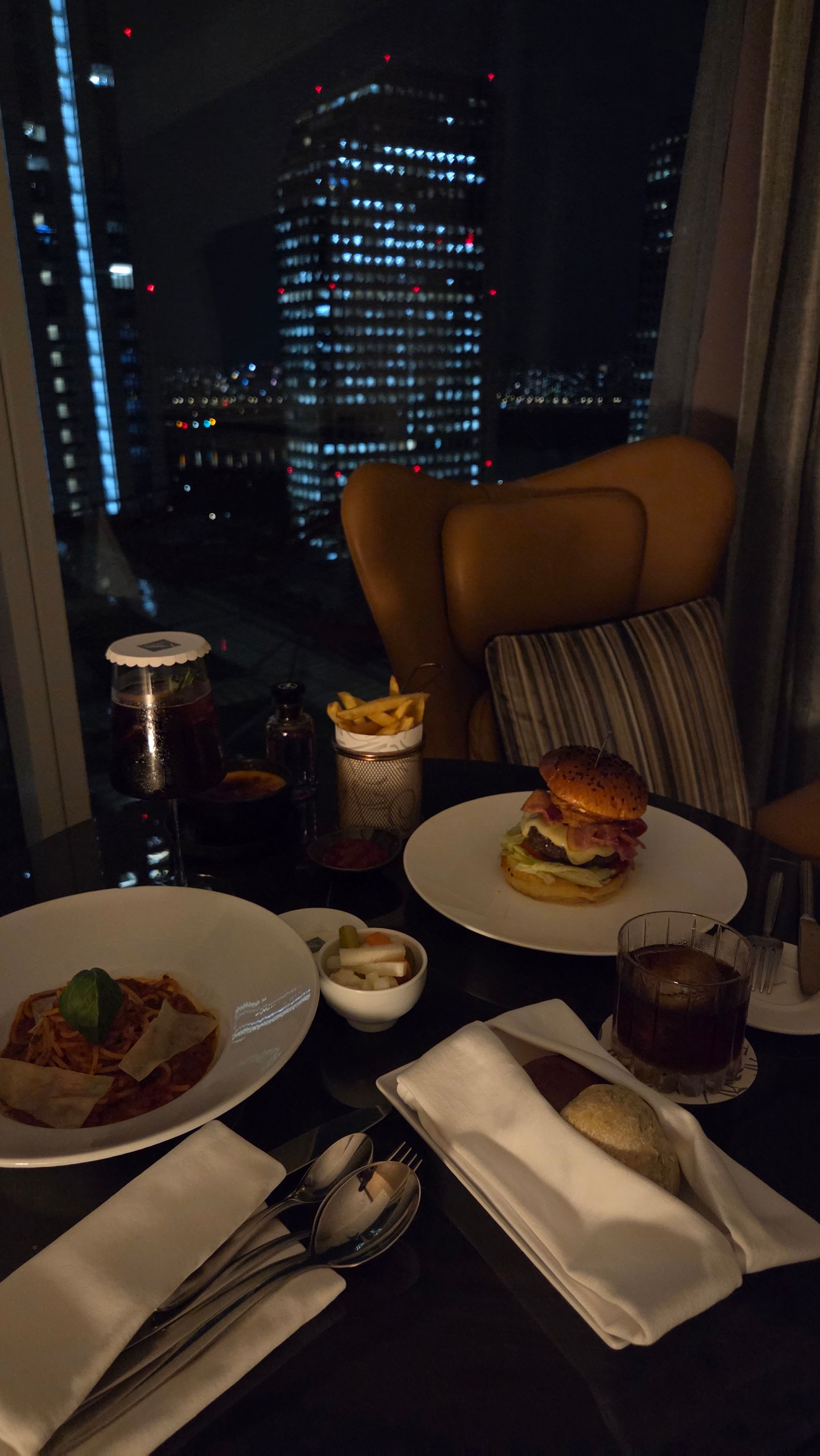 A Seoul hotel room-service table with a night city view.
