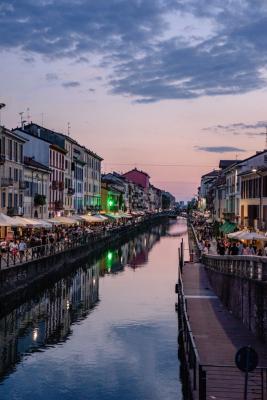 Persone lungo il Naviglio a Milano al tramonto