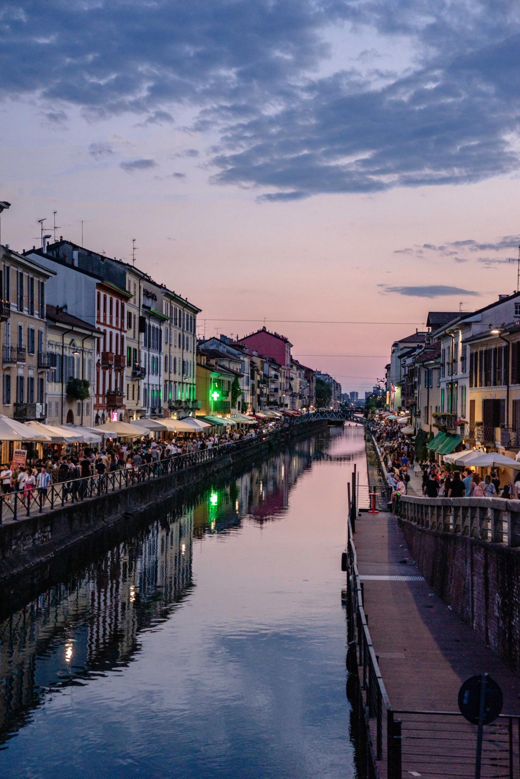 Persone lungo il Naviglio a Milano al tramonto