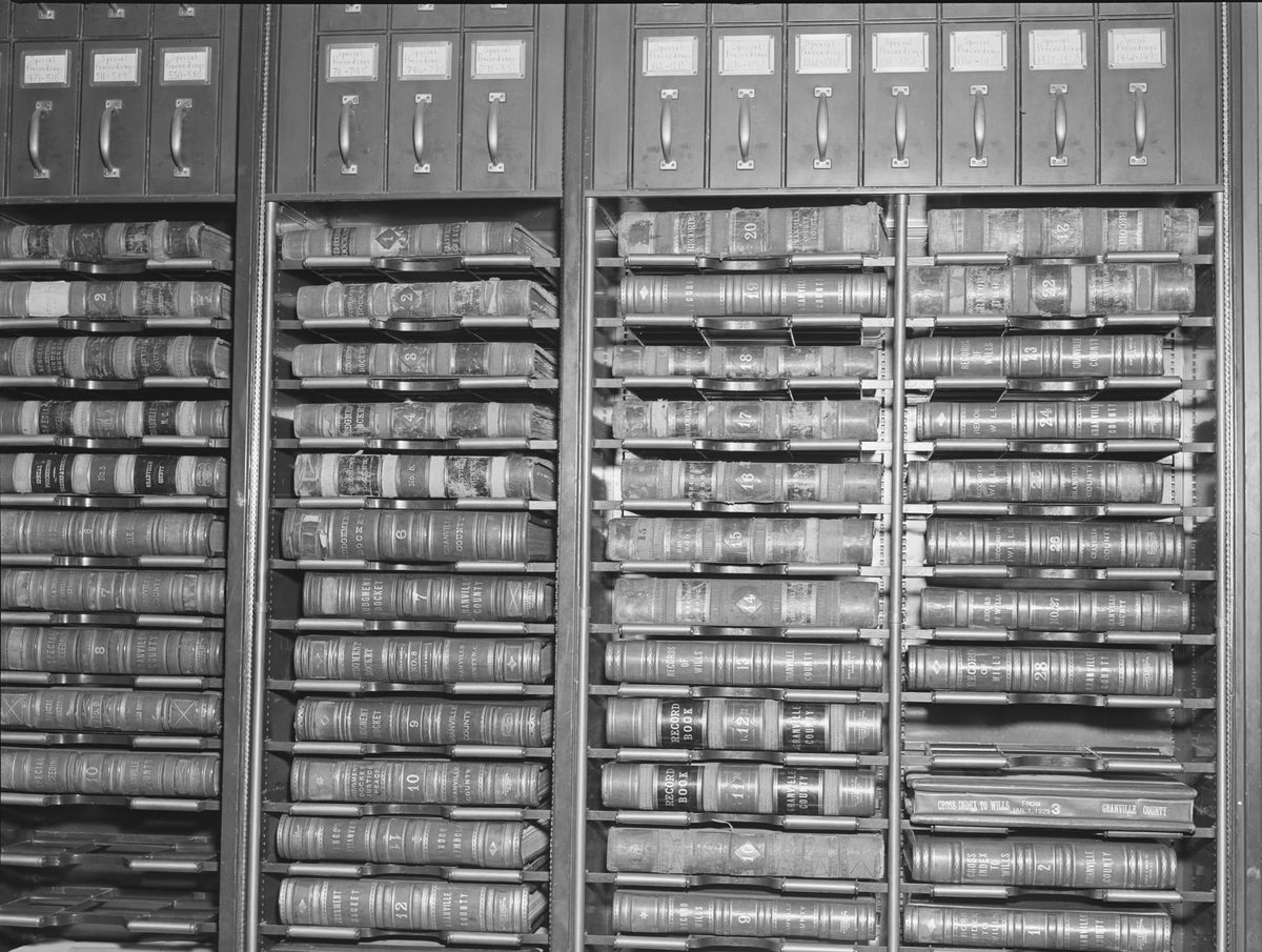 Shelves of leather-bound county record books with spines lettered Judgment Docket, Records of Wills and Granville County, and metal file drawers labeled Special Proceedings above.