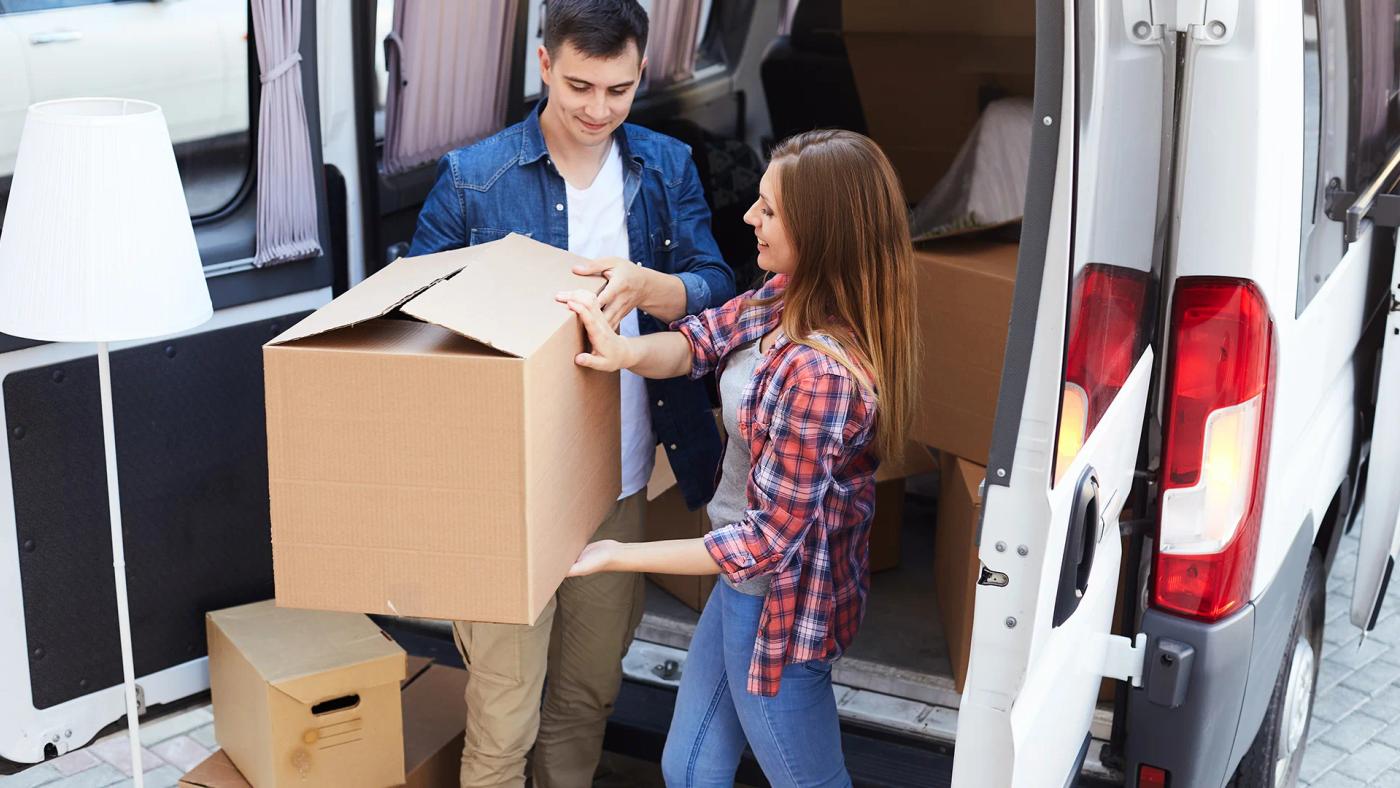 Modern couple unloading van