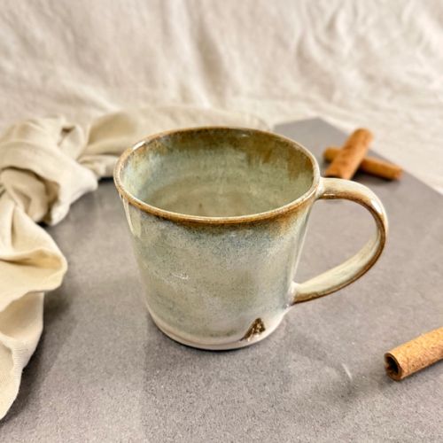 Handdrejad mugg i salvia rost glasyr, spräcklig salviagrön med varm rostbrun kant och rinningar, oglaserad fot