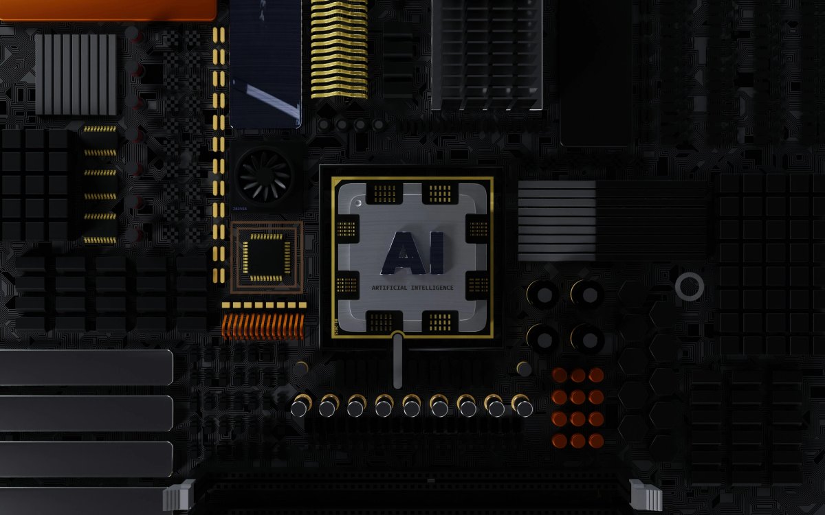 Close-up view of a dark computer motherboard featuring a central silver AI chip labeled "ARTIFICIAL INTELLIGENCE," surrounded by intricate circuitry, capacitors, and heat sinks.
