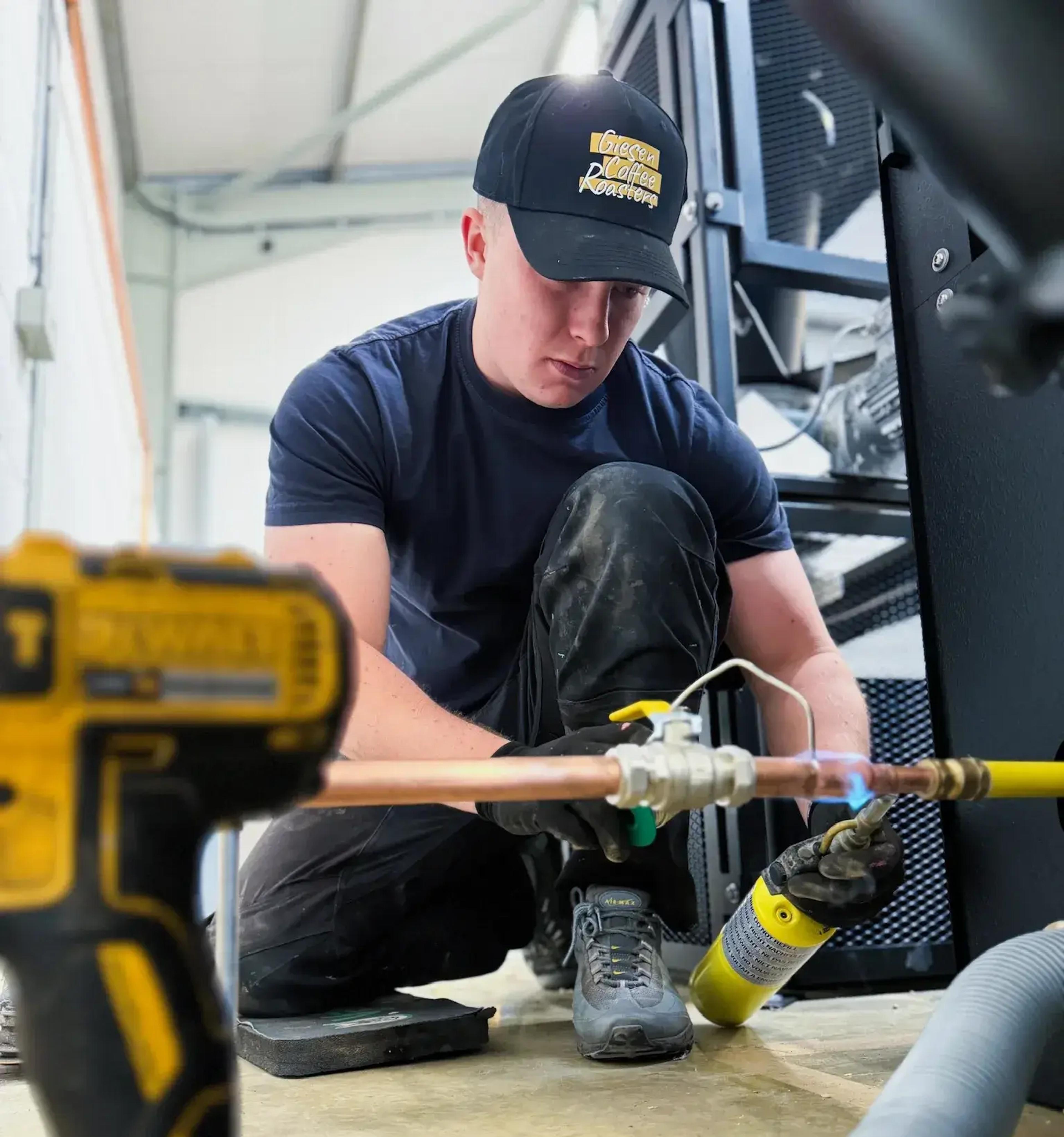 Engineer brazing a gas supply pipe during a Giesen coffee roaster installation