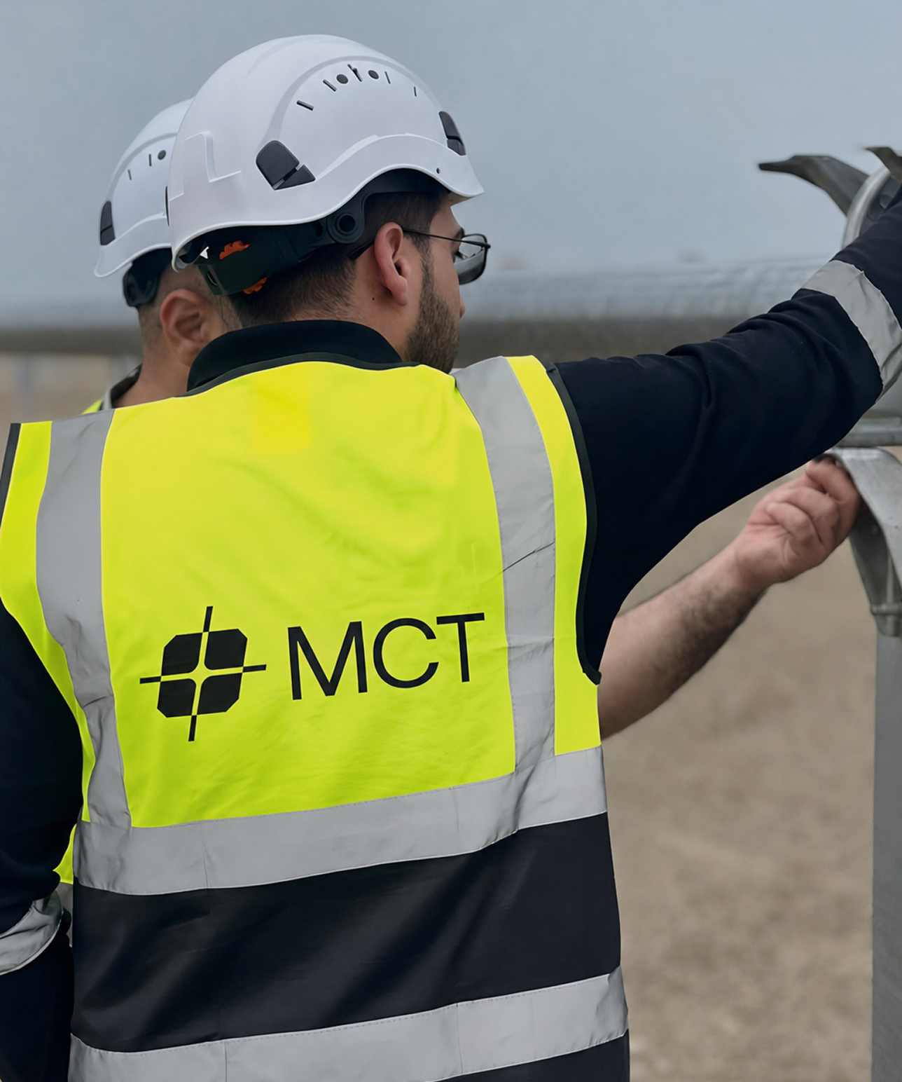 MCT site worker in a high-visibility safety vest and hard hat