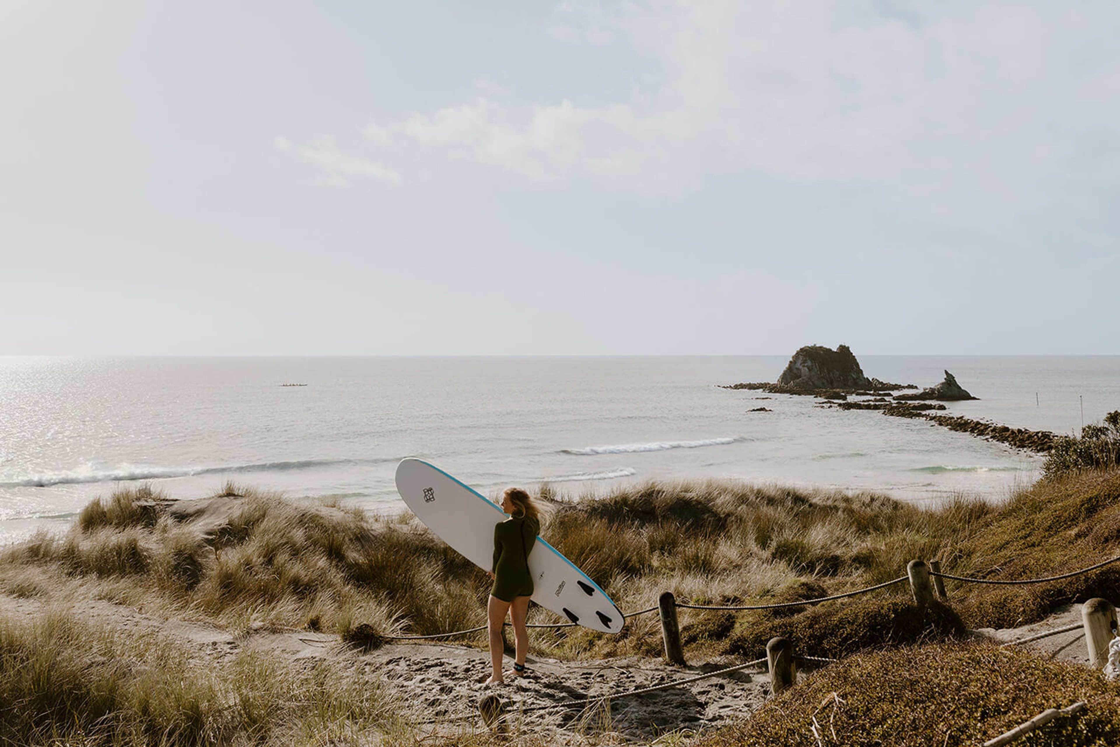 Surfer standing in the sand at the beach