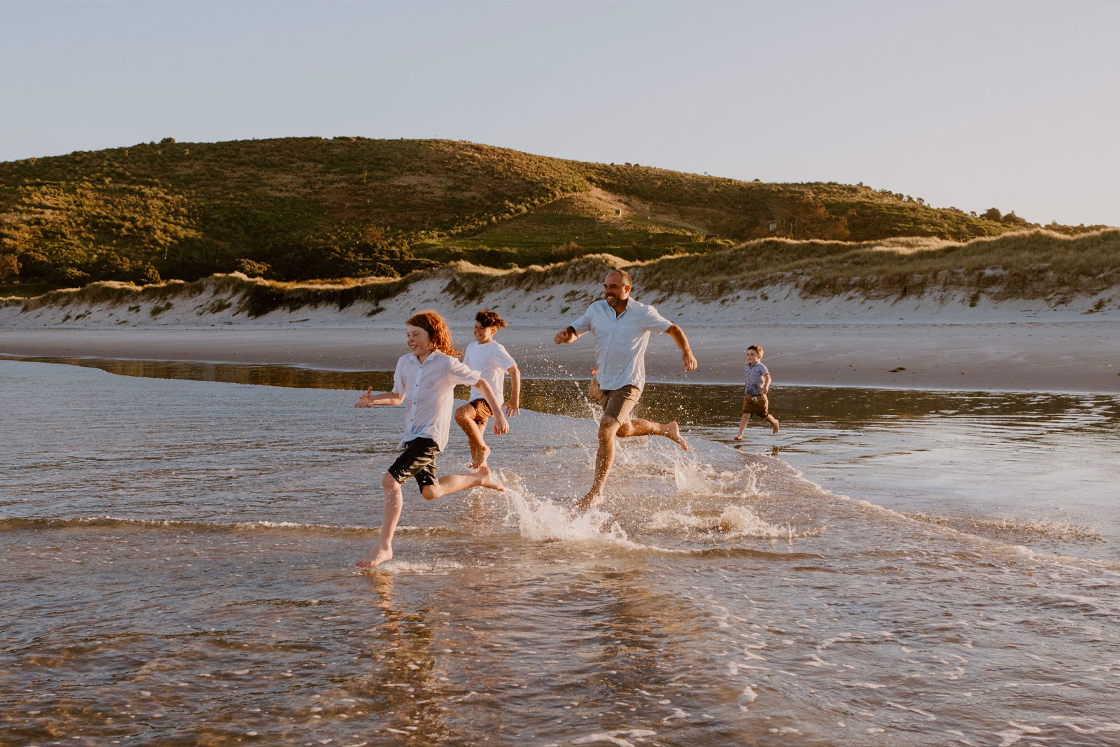 Family running along the beach