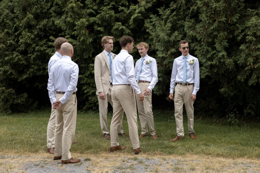Groomsmen waiting for bridal party portraits after wedding ceremony