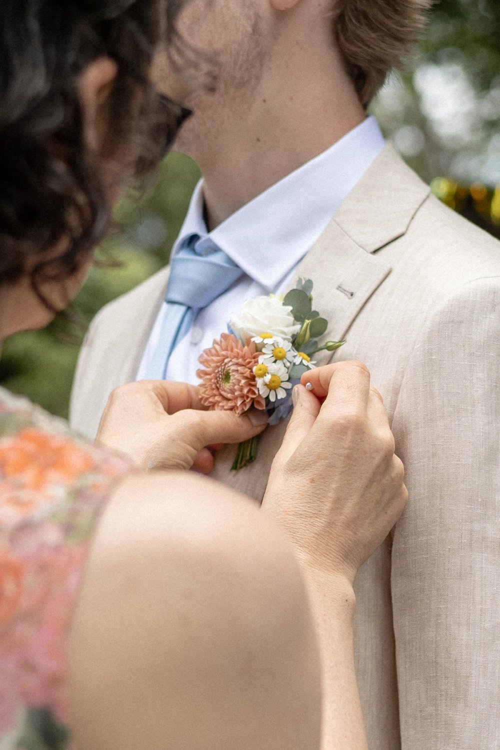mother of groom pinning boutonniere before Kurtz Orchard wedding ceremony Niagara-on-the-lake