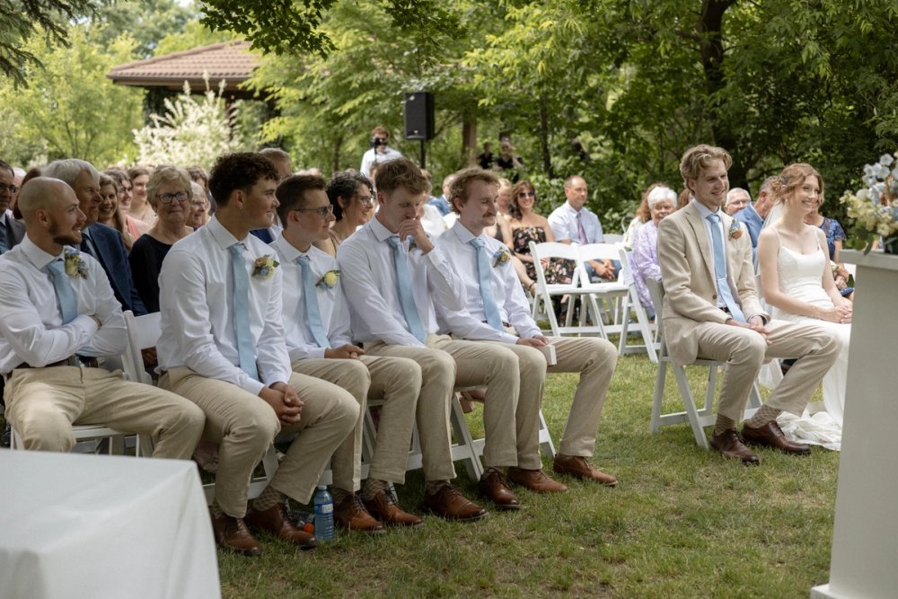 groomsmen seated during outdoor wedding ceremony at Kurtz Orchards