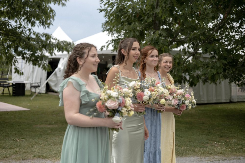 Bridesmaids watching couple as they get portraits before wedding ceremony