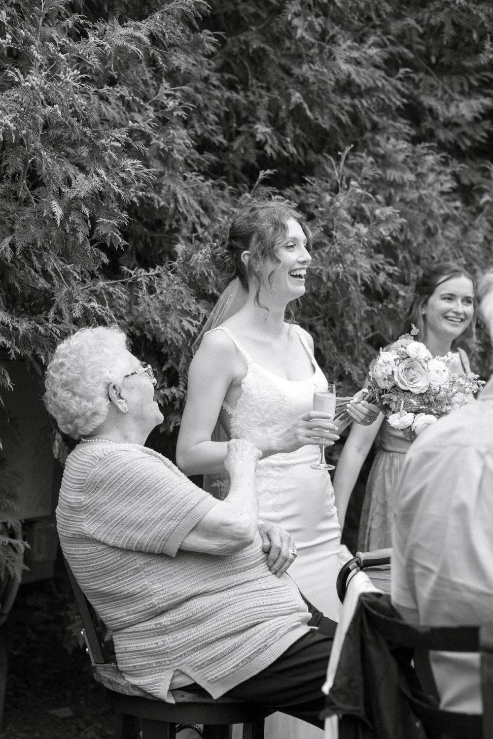 bride lauging with wedding guests during cocktail hour