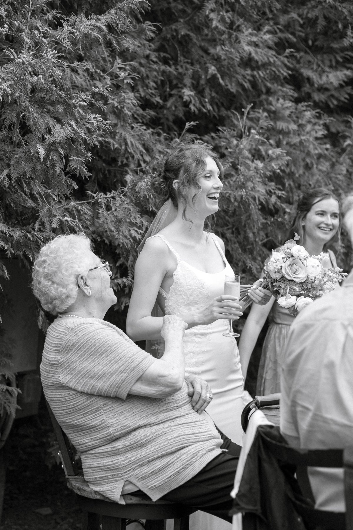 Bride and her grandmother laughing and holding hands during the ceremony, captured spontaneously.
