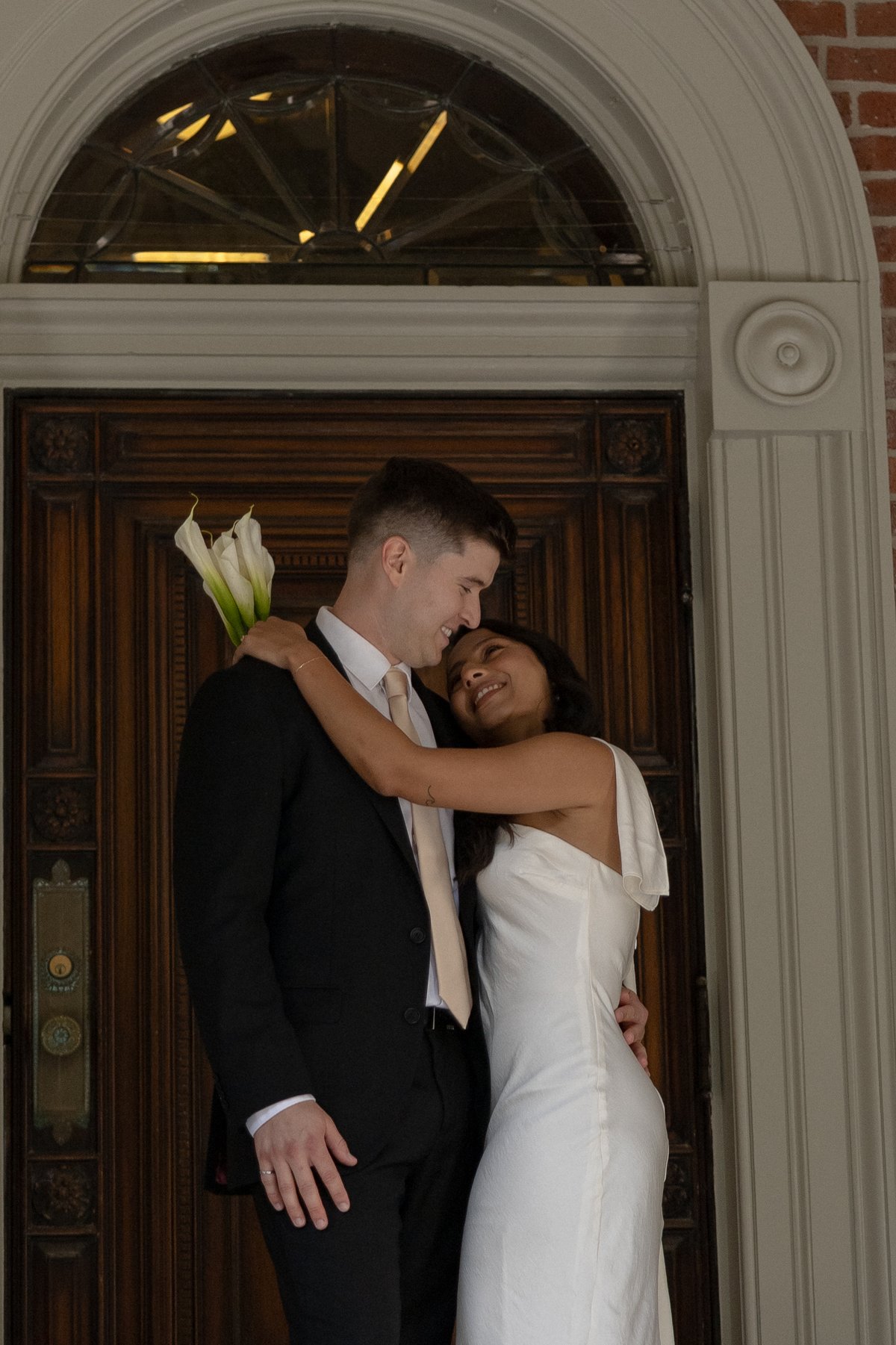 Bride and groom sharing a candid hug outside Osgoode Hall, captured by a documentary wedding photographer