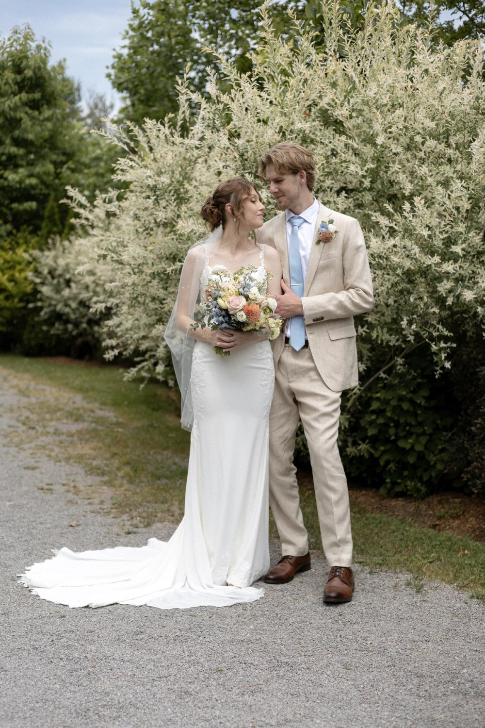 Wedding portraits along gravel path near Kurtz Orchards orchard
