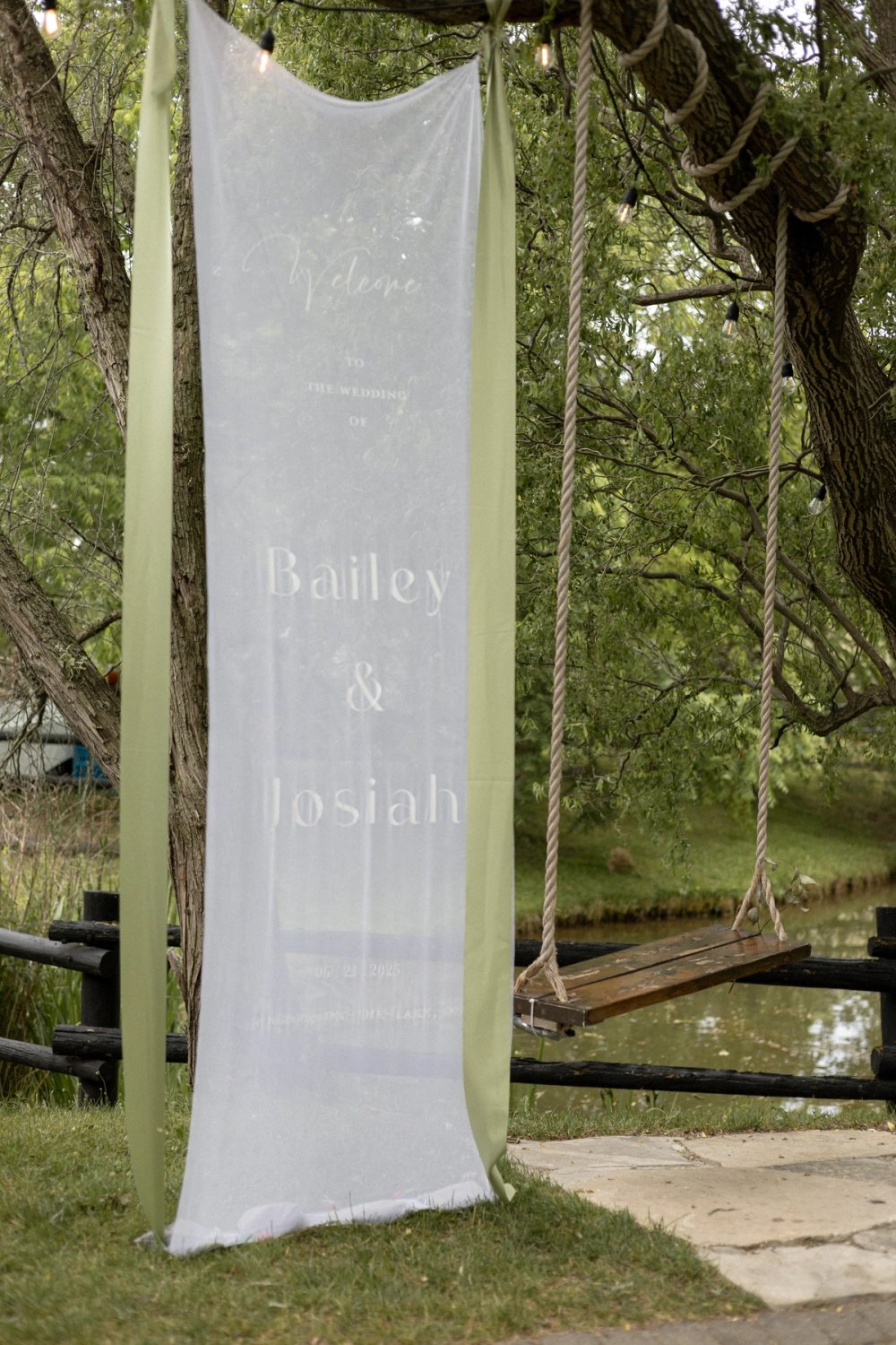 sheer wedding welcome banner next to rope swing