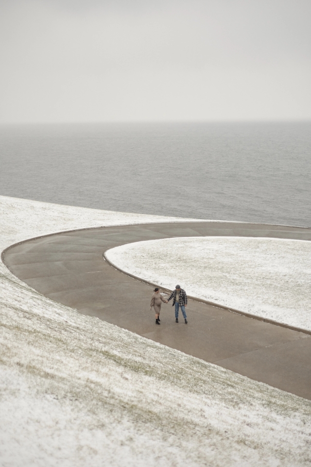 Distance photo of expecting parents walking on a path with an exquisite lakeside view at the R.C. Harris Water Treatment Plant.