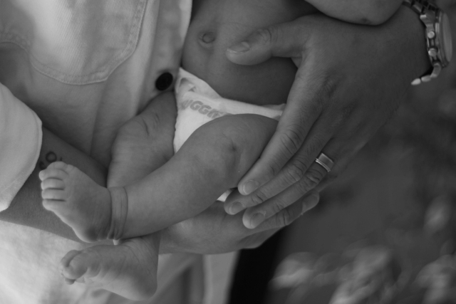 close up of dad cradling baby in arms, black & white - newborn photography