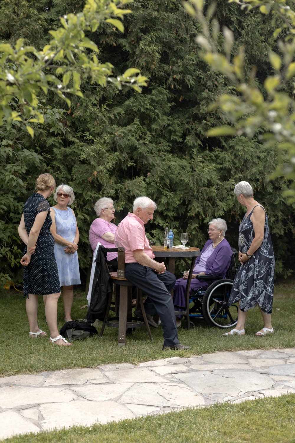 elderly guests enjoying cocktail reception surrounded by trees