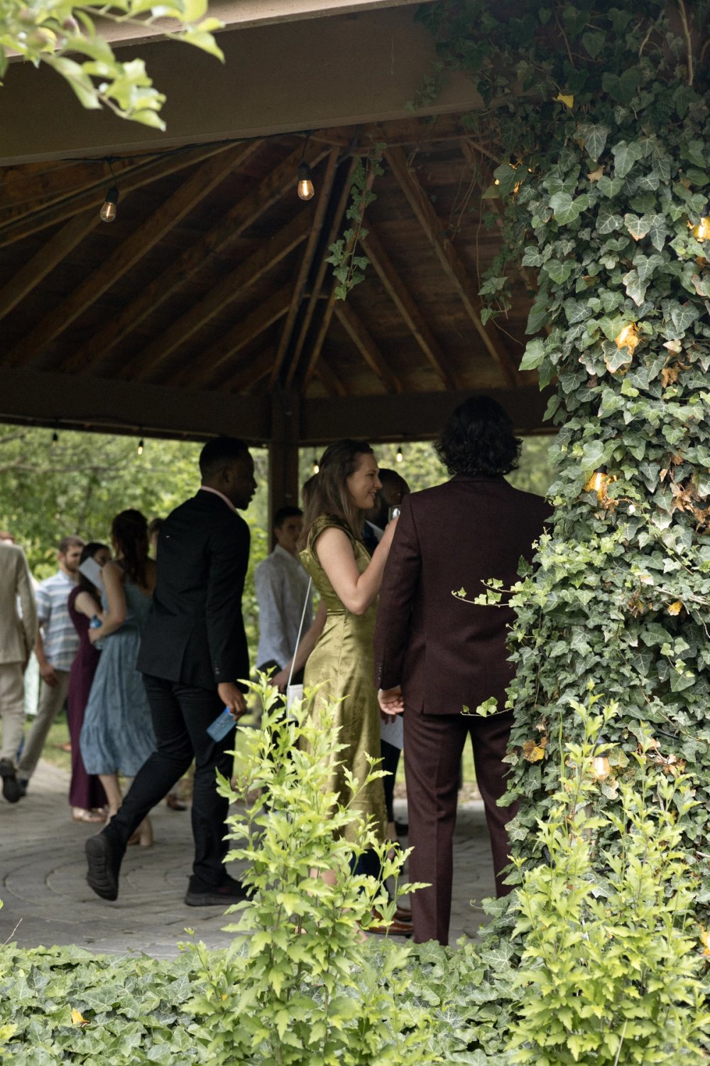 Guests gathering under gazebo before outdoor ceremony