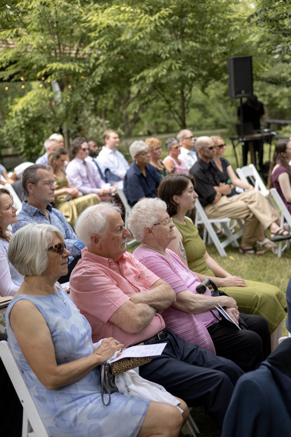 guests in pastel summer colours watching couple say vows at Niagara-on-the-Lake wedding ceremony