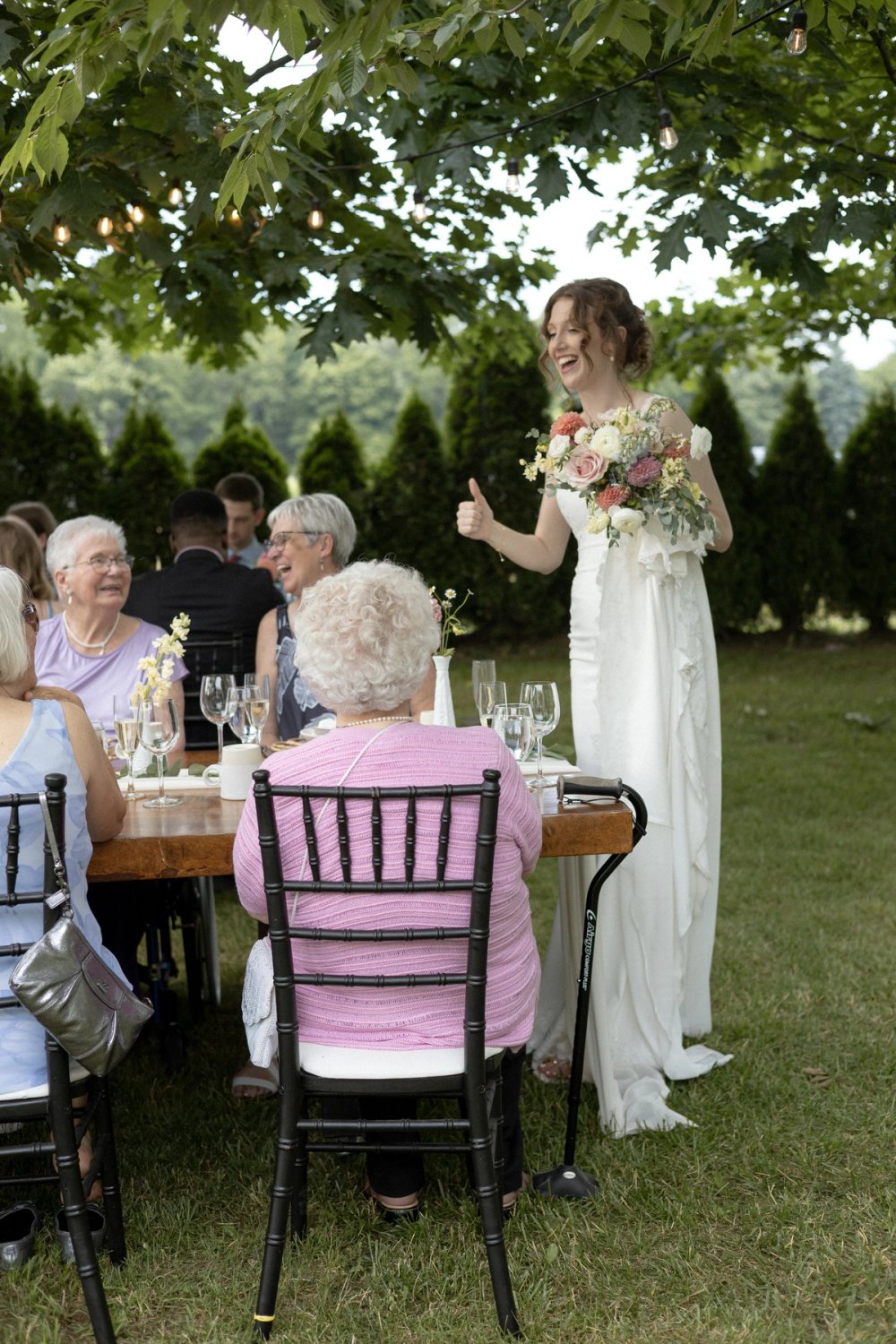 Bride celebrating with family at outdoor wedding reception