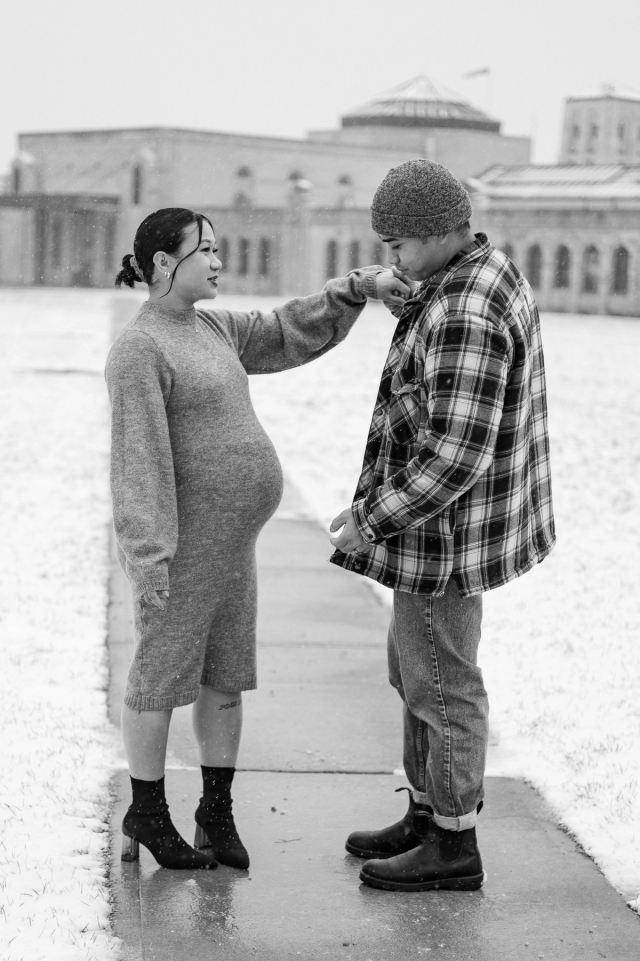 Expectant mother and father holding hands in front of R.C. Harris Water Treatment Plant. 