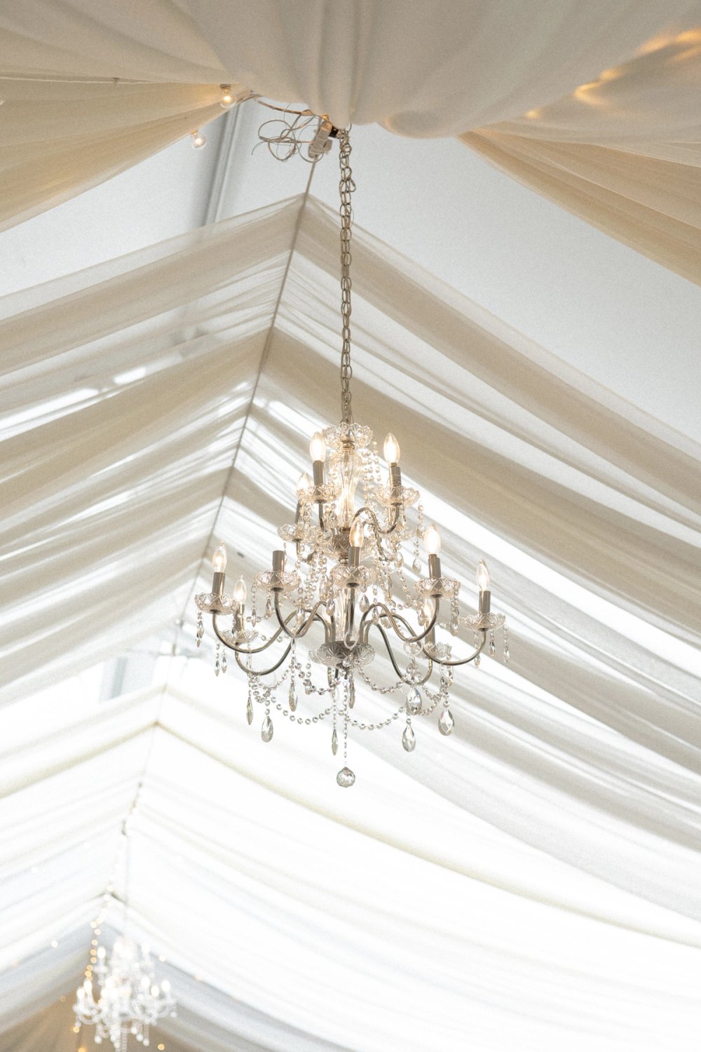 Chandelier hanging from wedding tent at Kurtz Orchards wedding reception