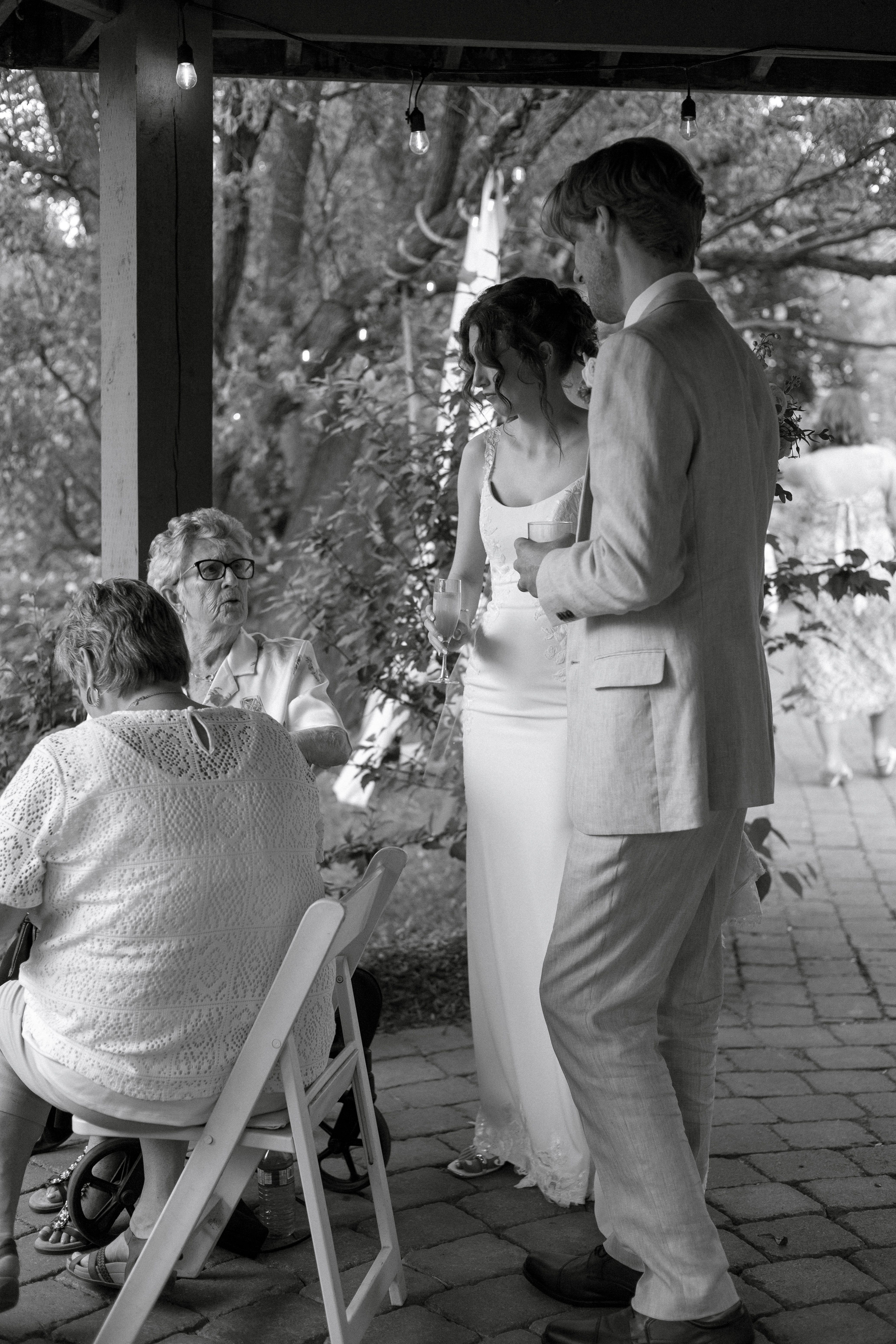 Couple talking with elderly family members under gazebo at Kurtz Orchards wedding