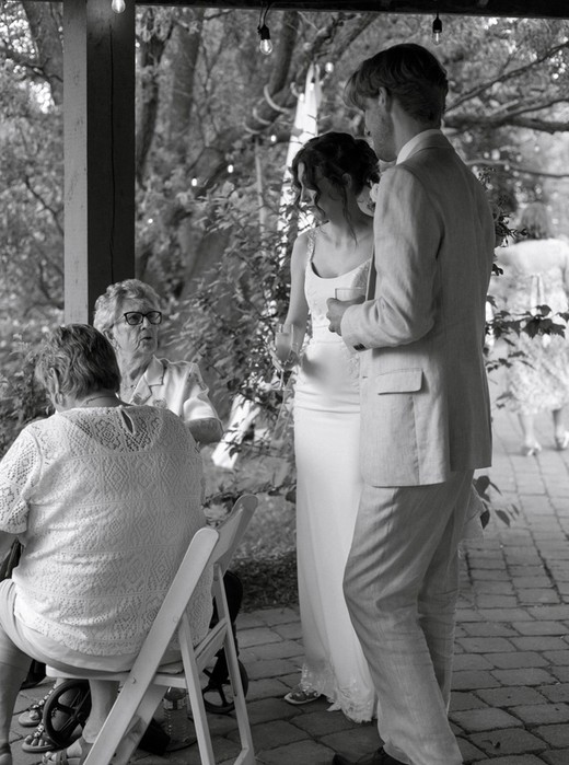 Couple talking with elderly family members under gazebo at Kurtz Orchards wedding