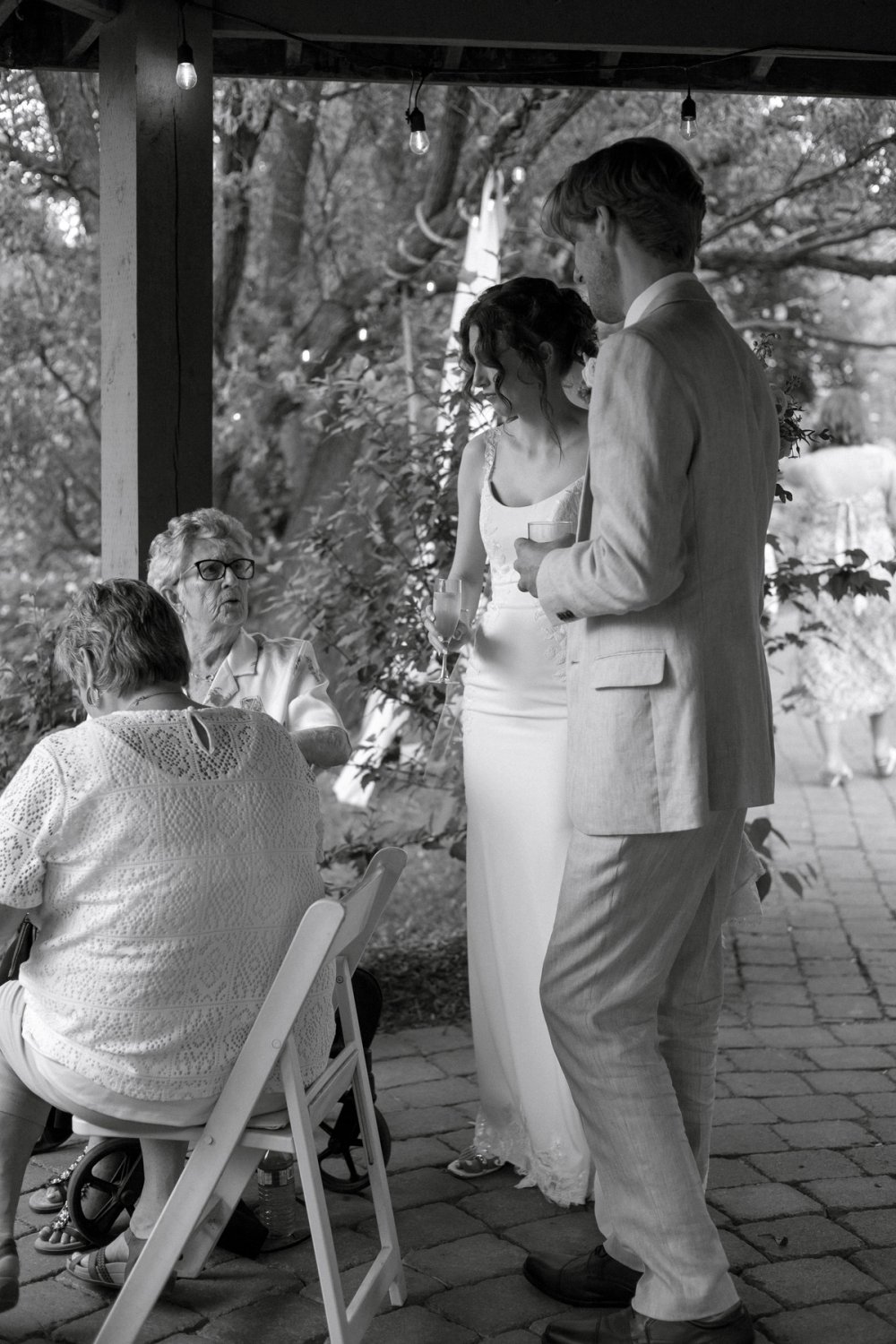 Couple talking with elderly family members under gazebo at Kurtz Orchards wedding