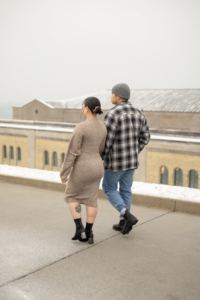 Candid maternity photo of an expectant mother and her partner walking near the iconic lakeside view at the R.C. Harris Water Treatment Plant