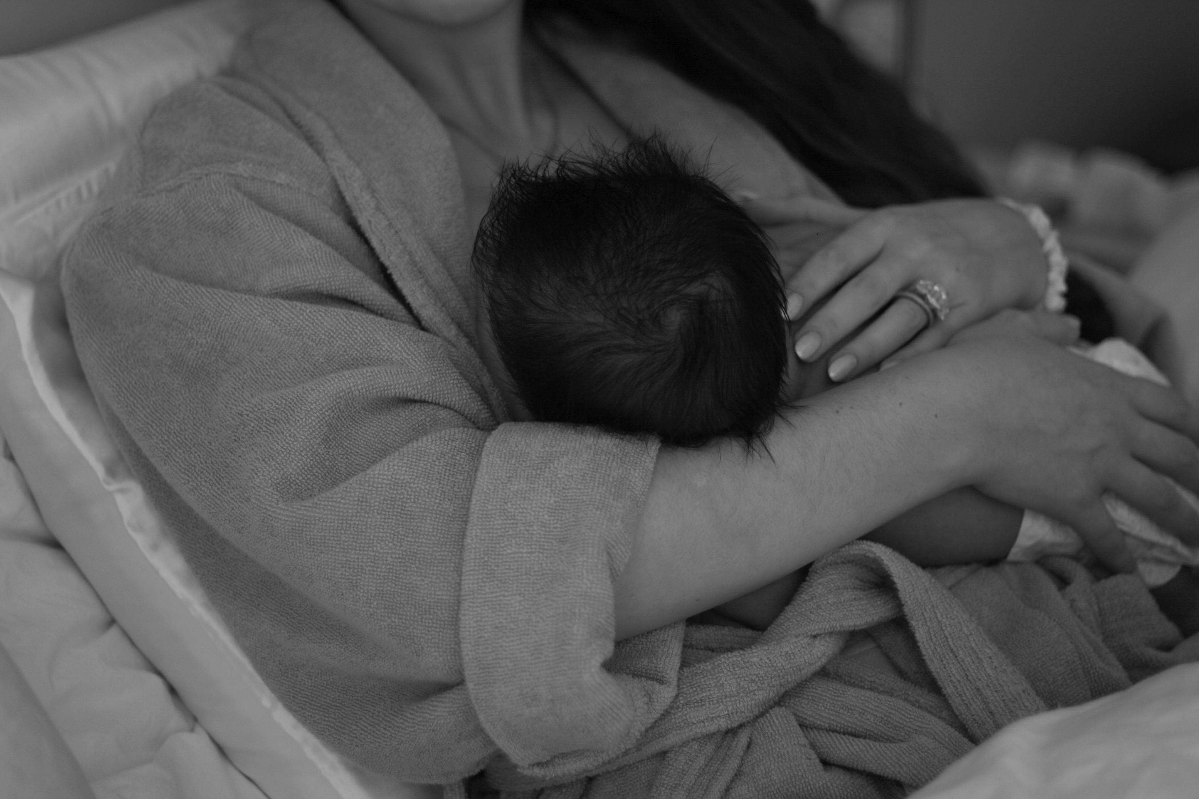 babys head resting in mom's arm while breastfeeding, black and white image - Newborn Photography