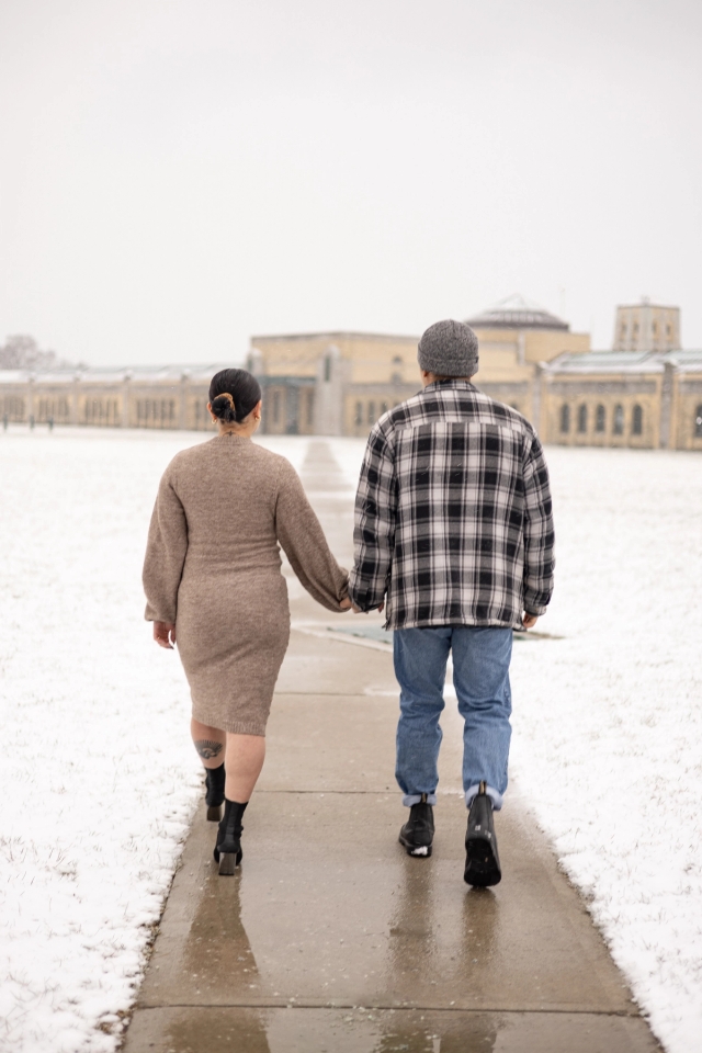 Pregnant woman in neutral dress holding hands and walking with husband toward the beautiful architecture of the R.C. Harris Water Treatment Plant. 